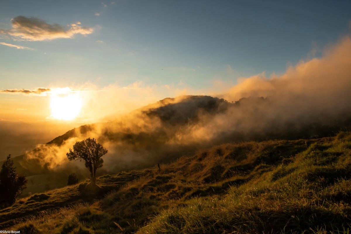 Volcan Barva émergeant de la brume et les lueurs du soleil